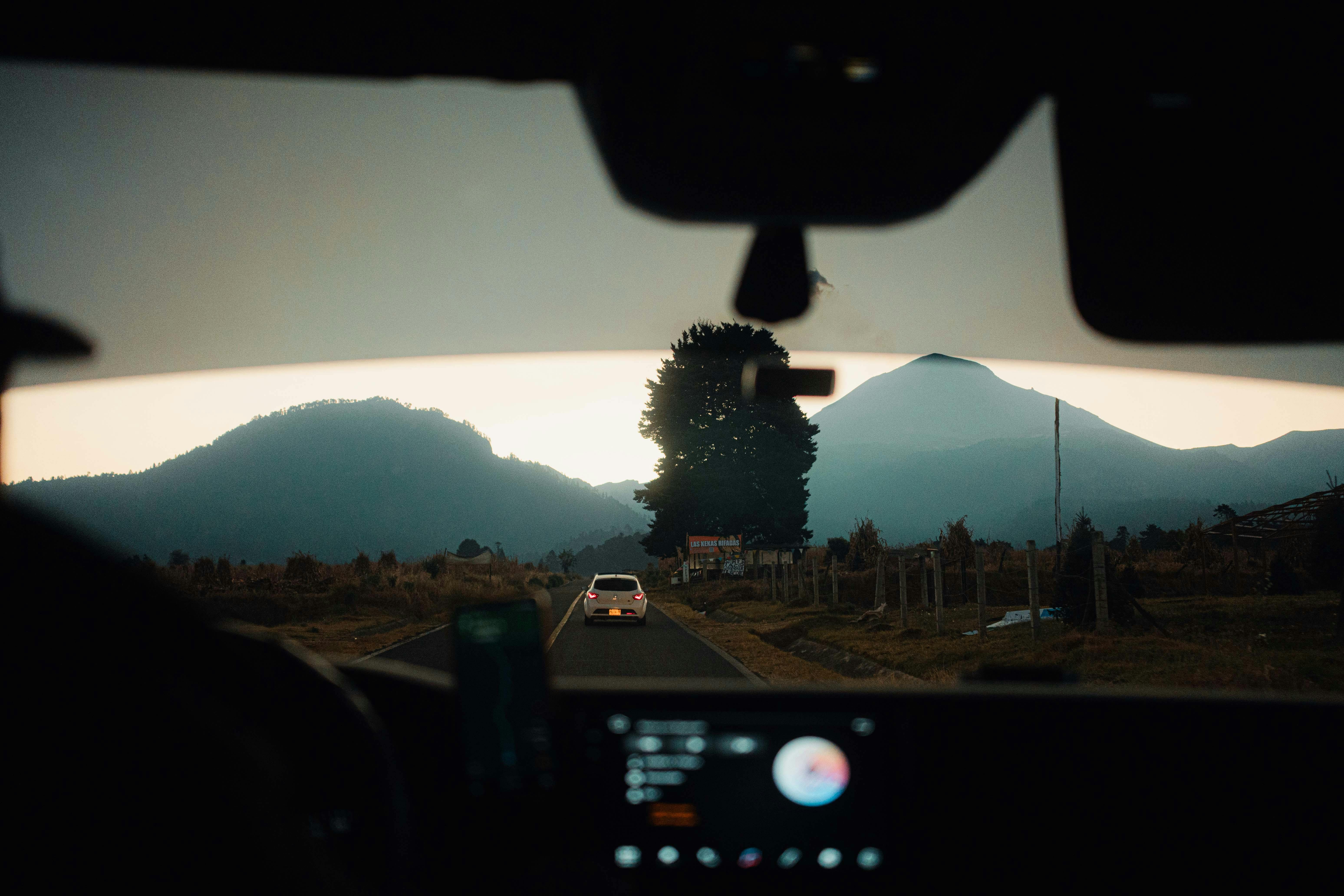 An image of inside a car with an audiobook on and mountains in the background 